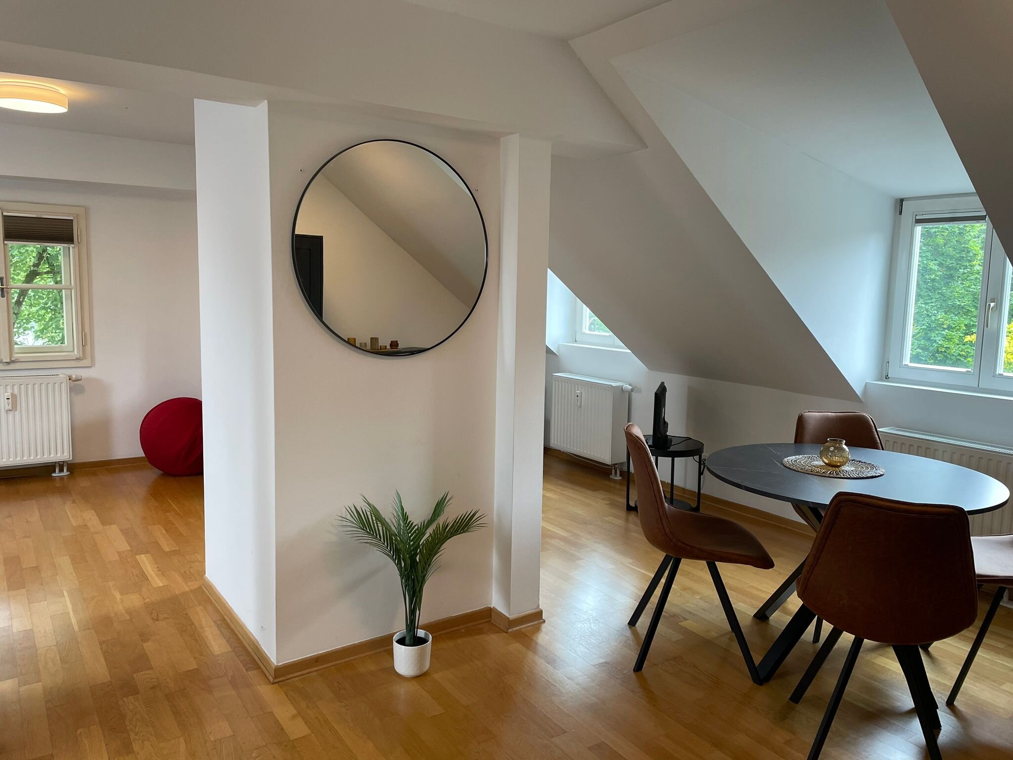 Bright living area with sloped ceiling & wood floor – 1-room apartment, short-term rental & temporary housing for 1 to 6 months in Salzburg