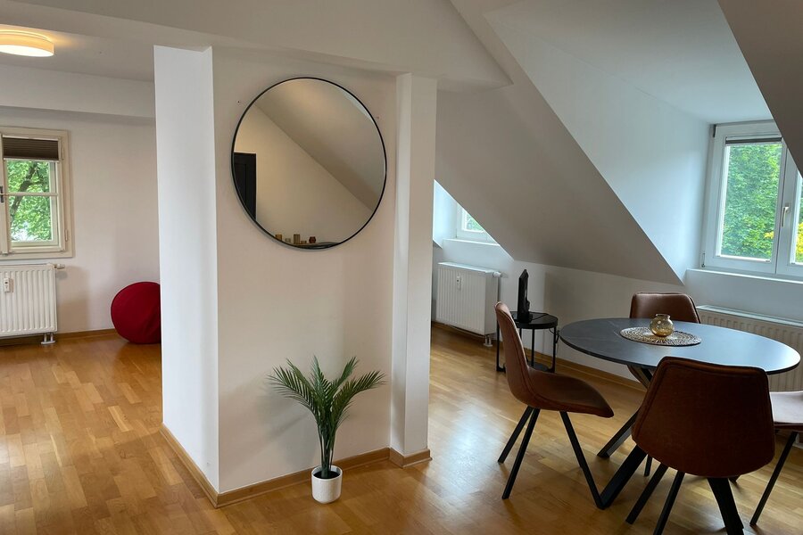 Bright living area with sloped ceiling & wood floor – 1-room apartment, short-term rental & temporary housing for 1 to 6 months in Salzburg