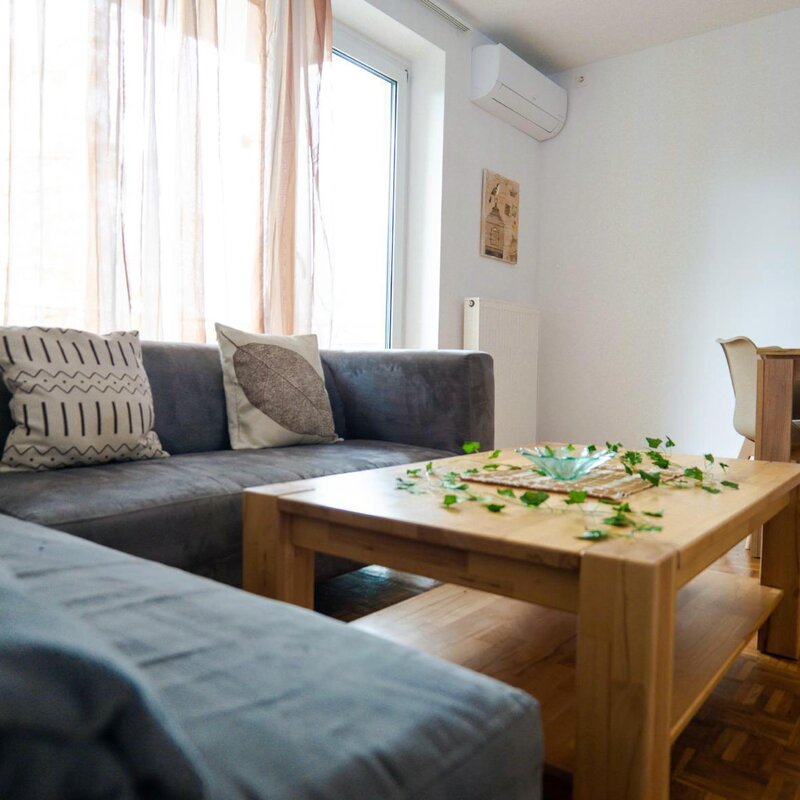 Bright living room with sofa & wood table – 3-room apartment, short-term rental, temporary housing 1 to 6 months, Linz