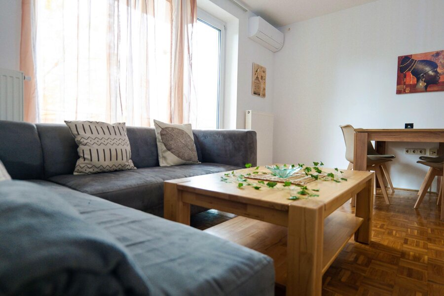 Bright living room with sofa & wood table – 3-room apartment, short-term rental, temporary housing 1 to 6 months, Linz
