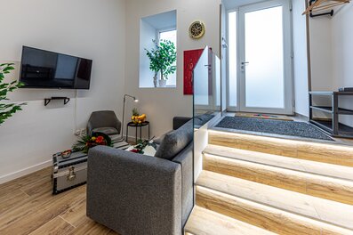 Modernes Wohnzimmer mit TV & beleuchteter Treppe – 2-Zimmer Apartment, Kurzzeitmiete Wien, Wohnen auf Zeit für 1 bis 6 Monate