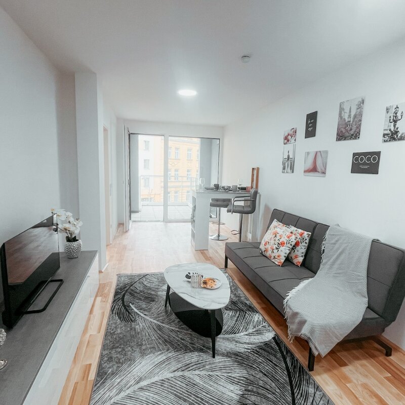 Bar table with chairs, modern dresser, flat-screen TV, rug, and coffee table, carefully selected furniture decoration that invites relaxation and enjoyment. | © All rights reserved