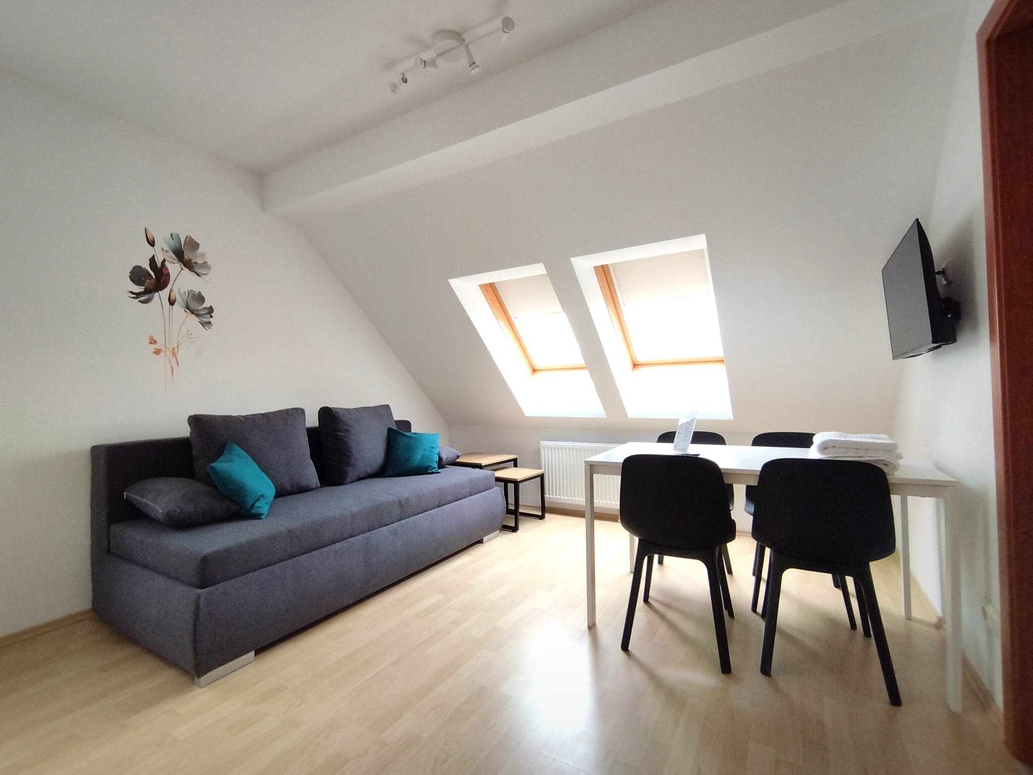 Helles Wohnzimmer mit Dachfenstern, Sofa & Esstisch – 2-Zimmer Wohnung, Kurzzeitmiete & Wohnen auf Zeit für 1 bis 6 Monate in Tattendorf