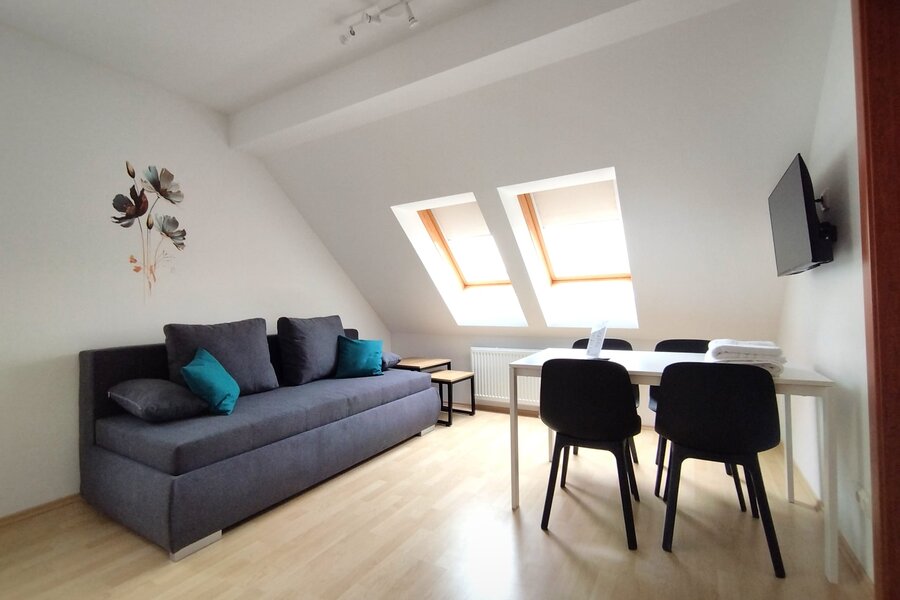Helles Wohnzimmer mit Dachfenstern, Sofa & Esstisch – 2-Zimmer Wohnung, Kurzzeitmiete & Wohnen auf Zeit für 1 bis 6 Monate in Tattendorf