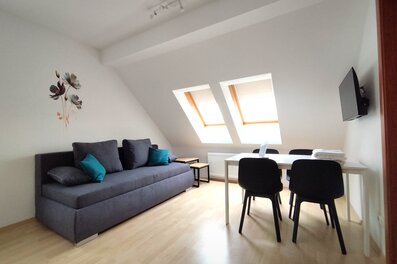 Bright living area with skylights, sofa & dining table – 2-room apartment, short-term rental & temporary housing for 1 to 6 months in Tattendorf