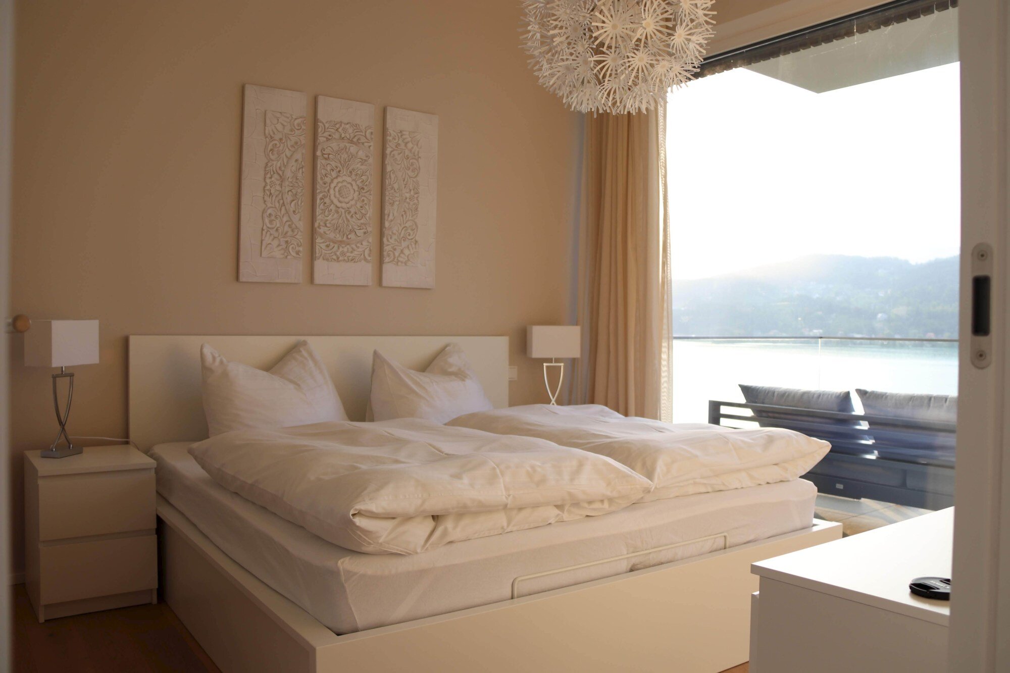 Schlafzimmer mit Zugang zum Balkon und Seeblick