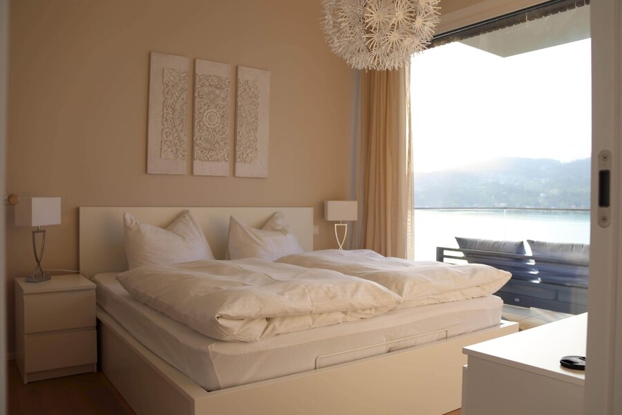 Schlafzimmer mit Zugang zum Balkon und Seeblick