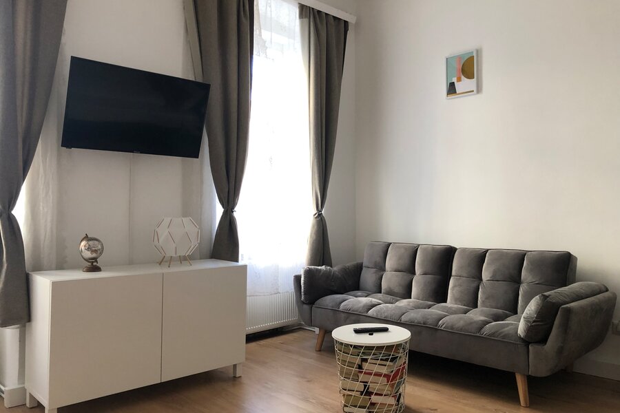 Helles Wohnzimmer mit Sofa & TV: 2-Zimmer Wohnung zur Kurzzeitmiete, Wohnen auf Zeit für 1 bis 6 Monate in Wien