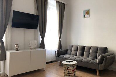 Helles Wohnzimmer mit Sofa & TV: 2-Zimmer Wohnung zur Kurzzeitmiete, Wohnen auf Zeit für 1 bis 6 Monate in Wien