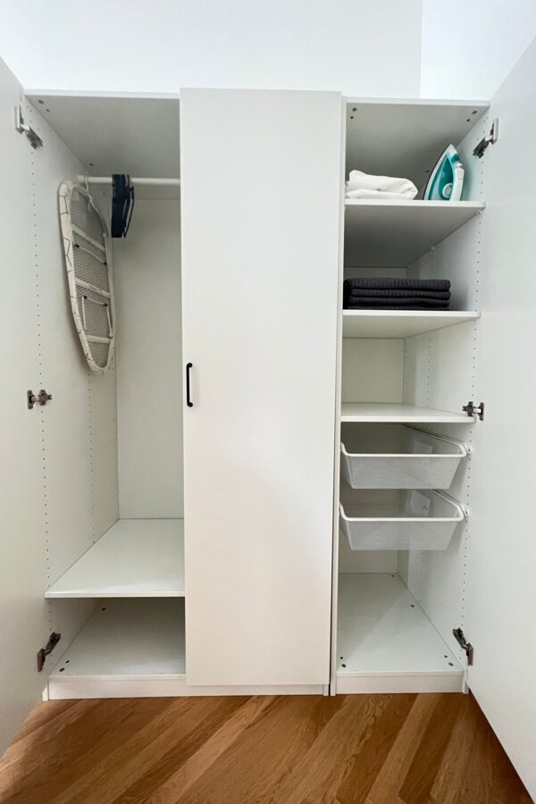 Spacious closet with towels, bed linen and iron
