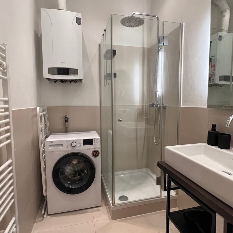 Bathroom with rain shower, washing machine, rotary dryer and hairdryer