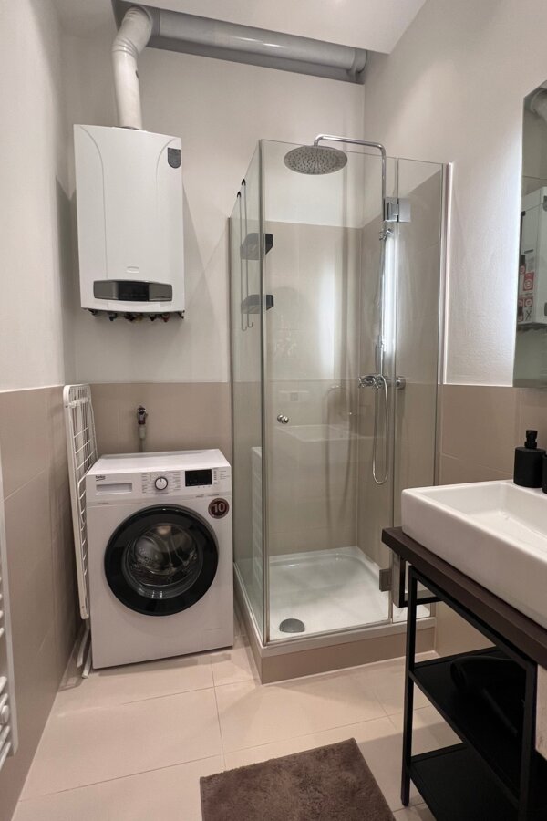 Bathroom with rain shower, washing machine, rotary dryer and hairdryer