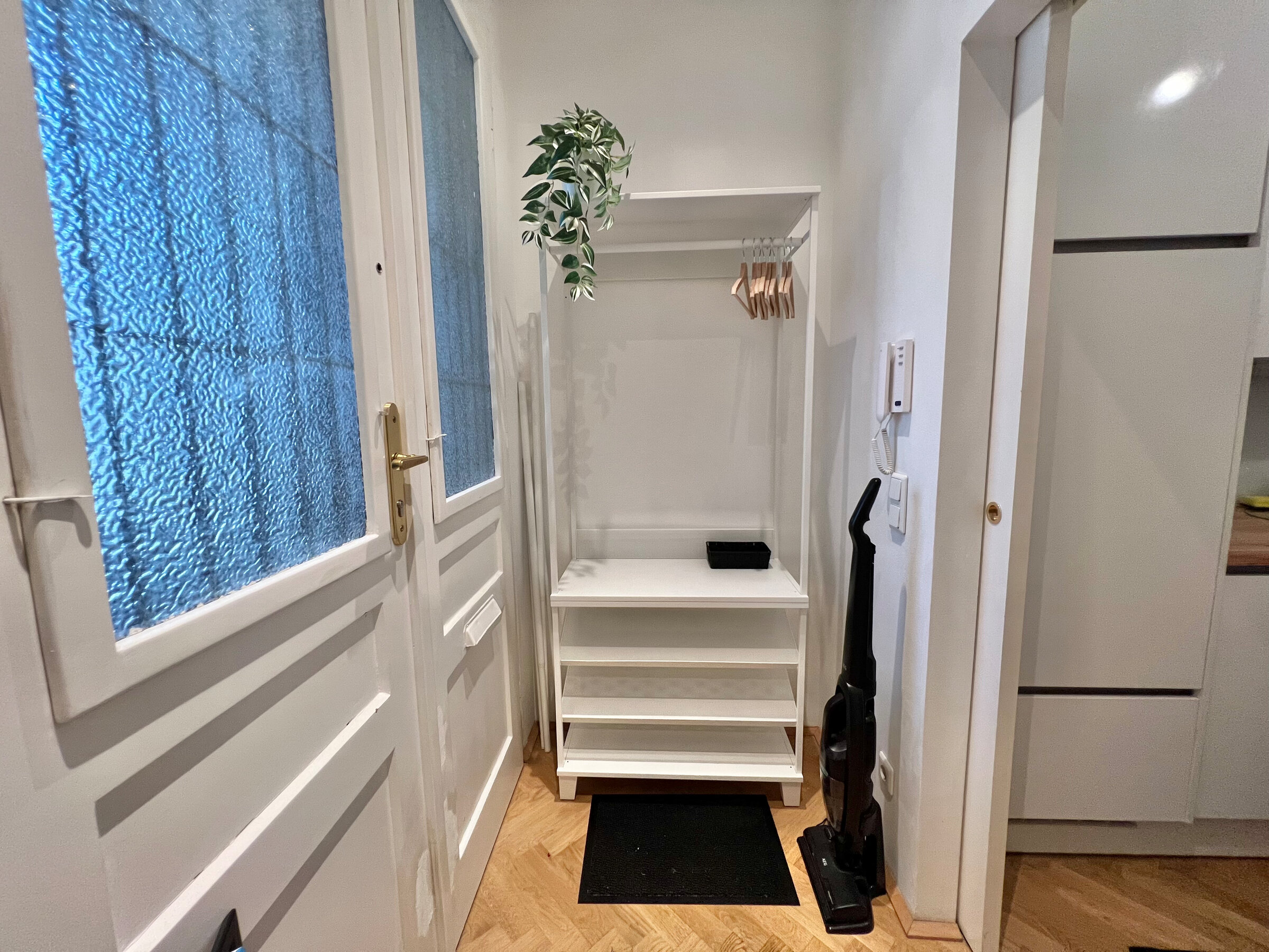 Daylight-flooded entrance hall with checkroom, mirror and shoe rack