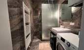 Badezimmer mit Fußbodenheizung, Regendusche und Waschmaschine