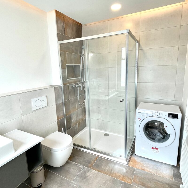 bathroom with toilette, shower and washing machine