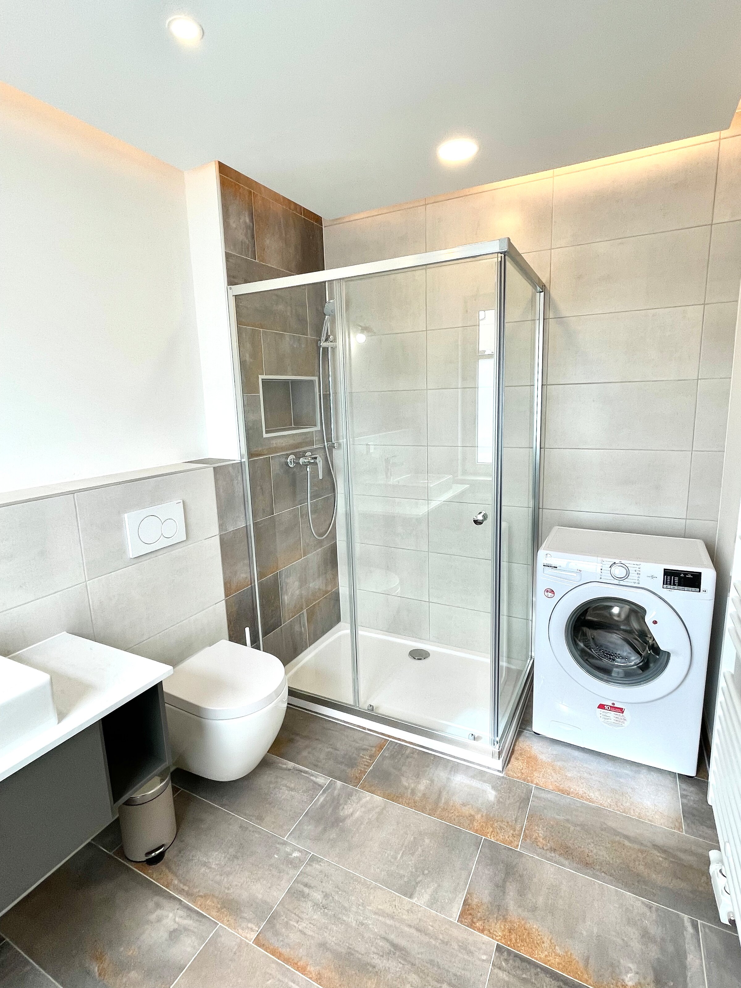 bathroom with toilette, shower and washing machine