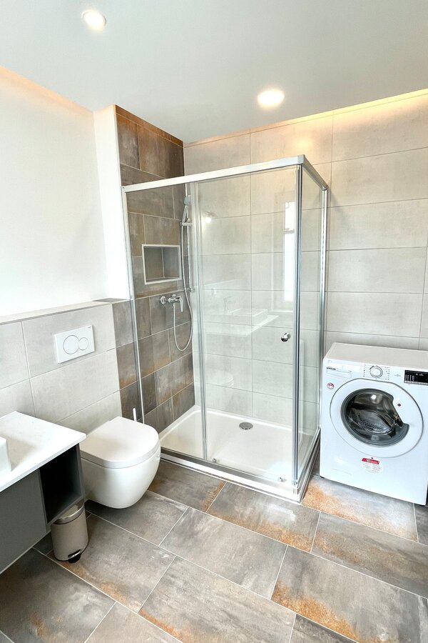 bathroom with toilette, shower and washing machine