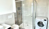 bathroom with toilette, shower and washing machine