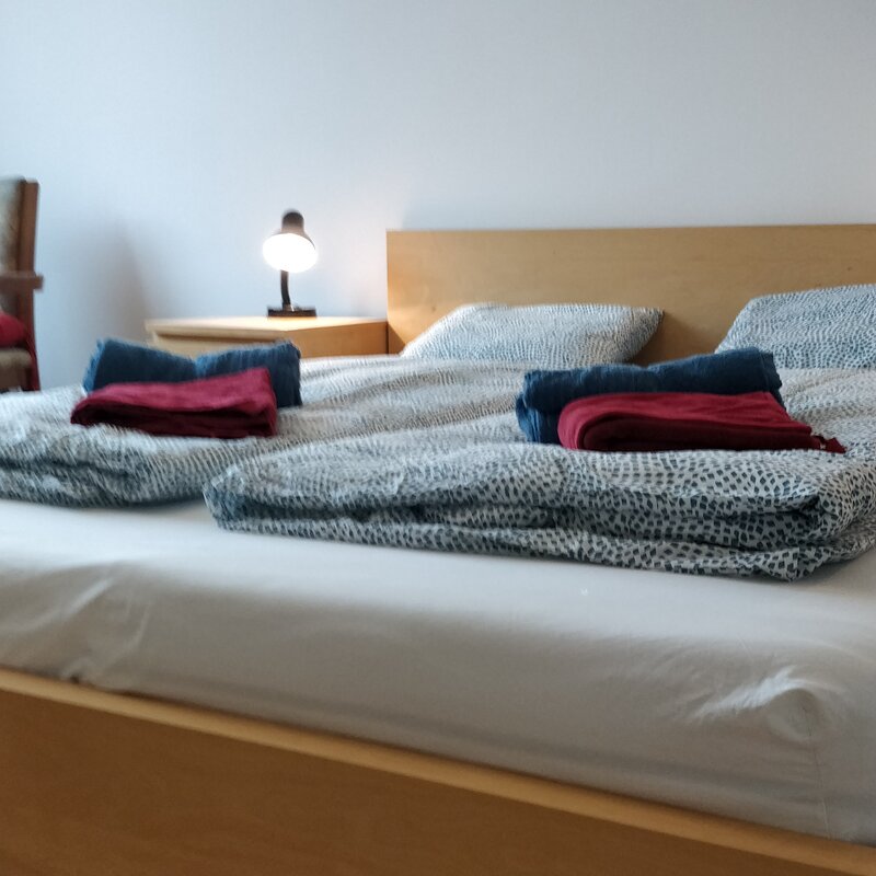 Bright bedroom with double bed & bedside lamp – 1-room apartment for short-term rental & temporary housing for 1 to 6 months in Vienna