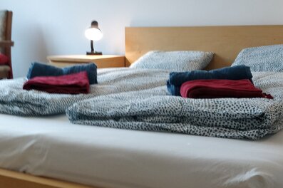 Bright bedroom with double bed & bedside lamp – 1-room apartment for short-term rental & temporary housing for 1 to 6 months in Vienna