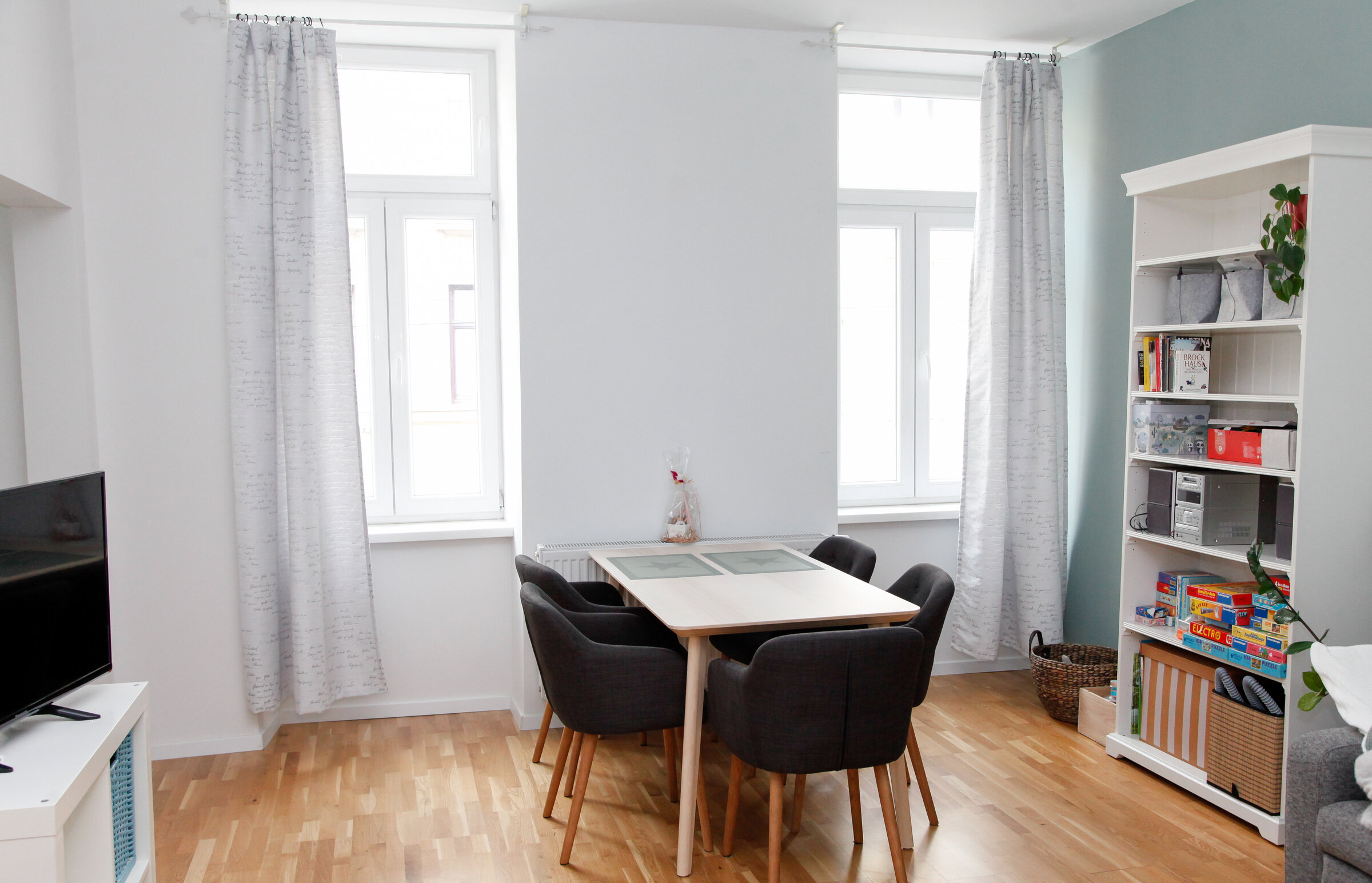 Wohnzimmer mit Essbereich und Couch, Bücherregal, Stereoanlage, TV