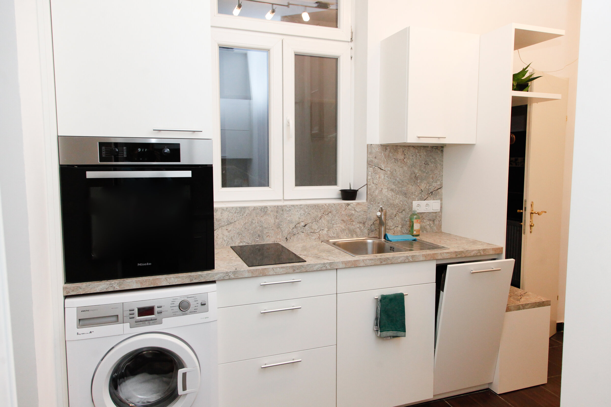 Küchenzeile rechts mit Backrohr, Herd, Waschmaschine, Geschirrspüler, Wasserkocher