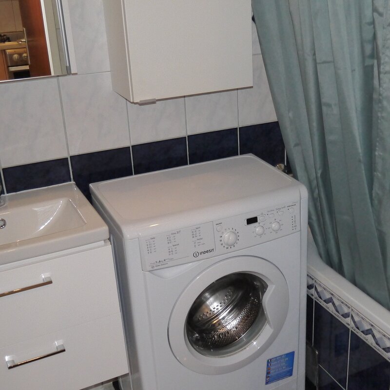 Badezimmer mit Badewanne und Waschmaschine