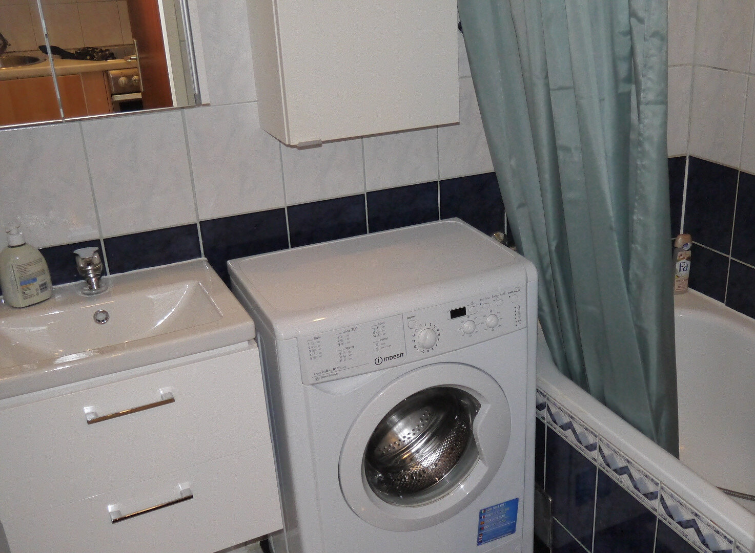 Badezimmer mit Badewanne und Waschmaschine