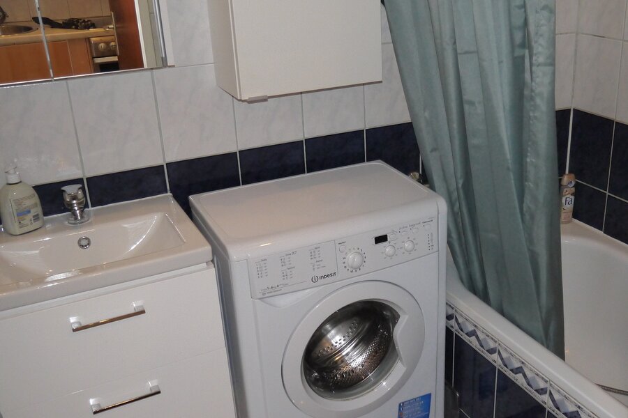 Badezimmer mit Badewanne und Waschmaschine