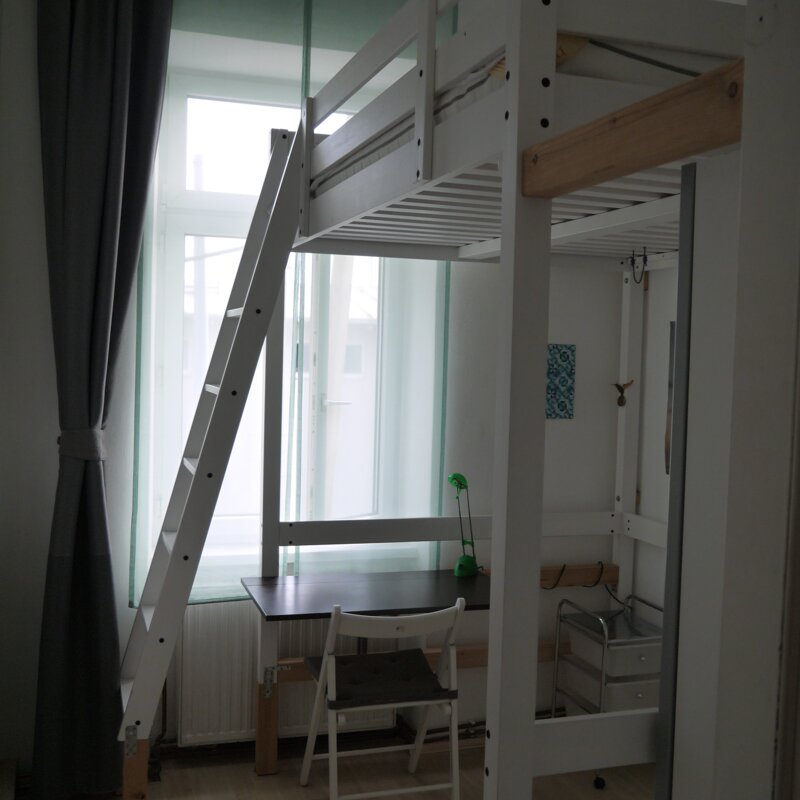 Schlafzimmer mit Blick auf Schreibtisch und rechts Kleiderschrank