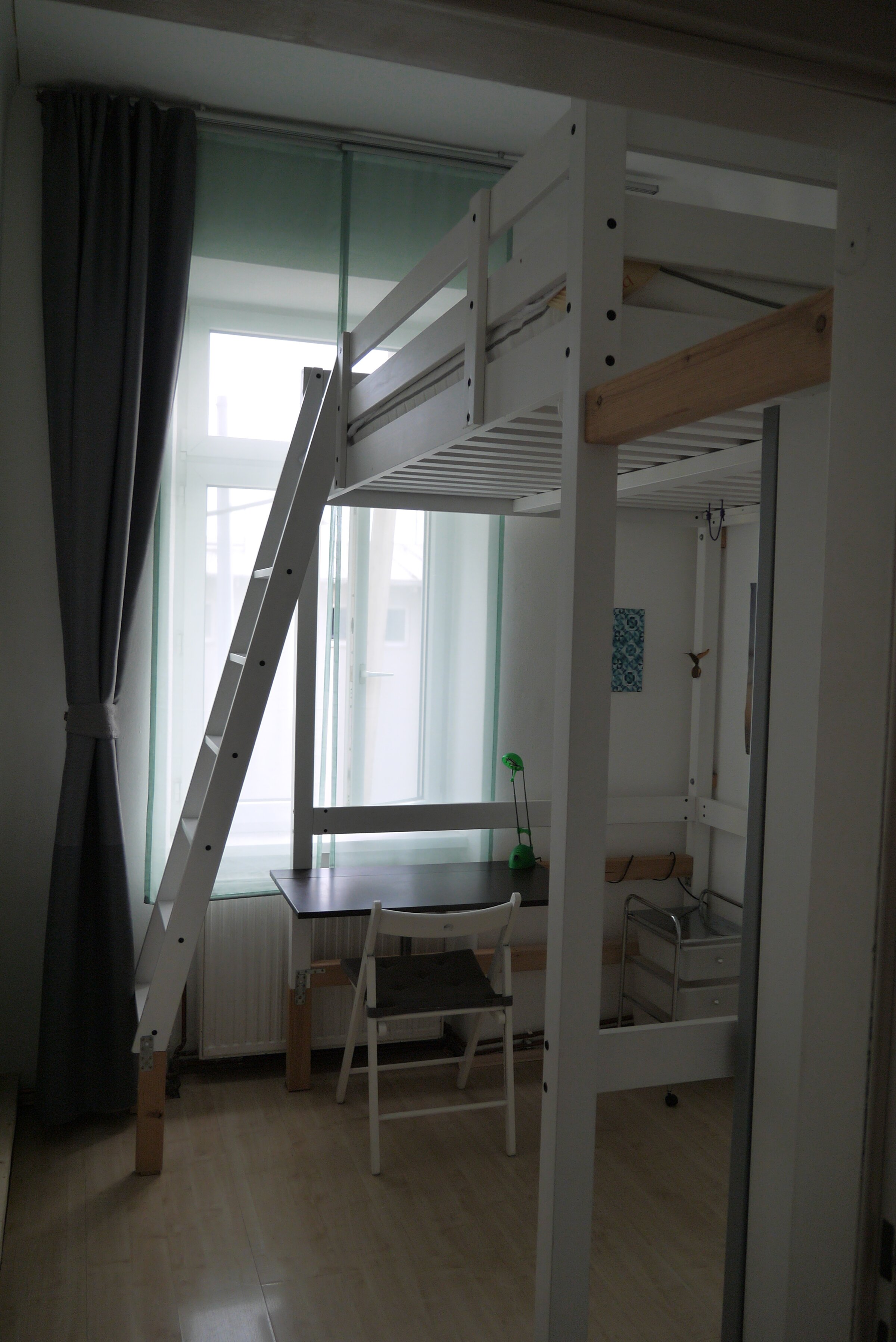 Schlafzimmer mit Blick auf Schreibtisch und rechts Kleiderschrank