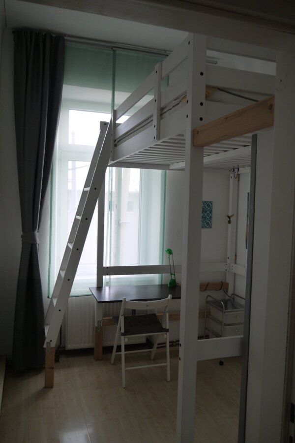 Schlafzimmer mit Blick auf Schreibtisch und rechts Kleiderschrank