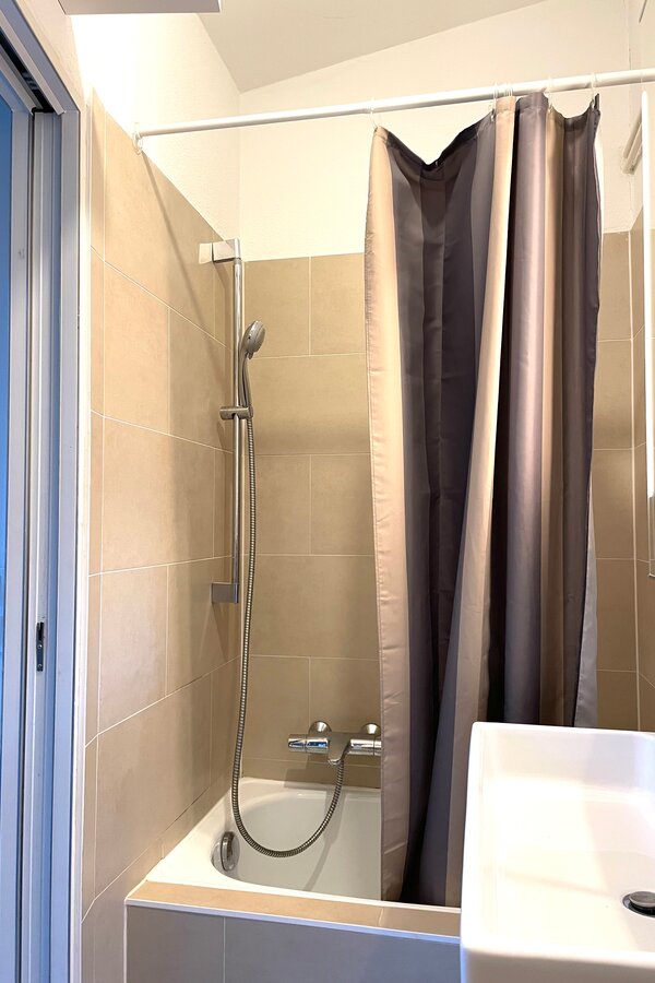 Dusche mit Duschvorhang und kleiner Badewanne | © Winter