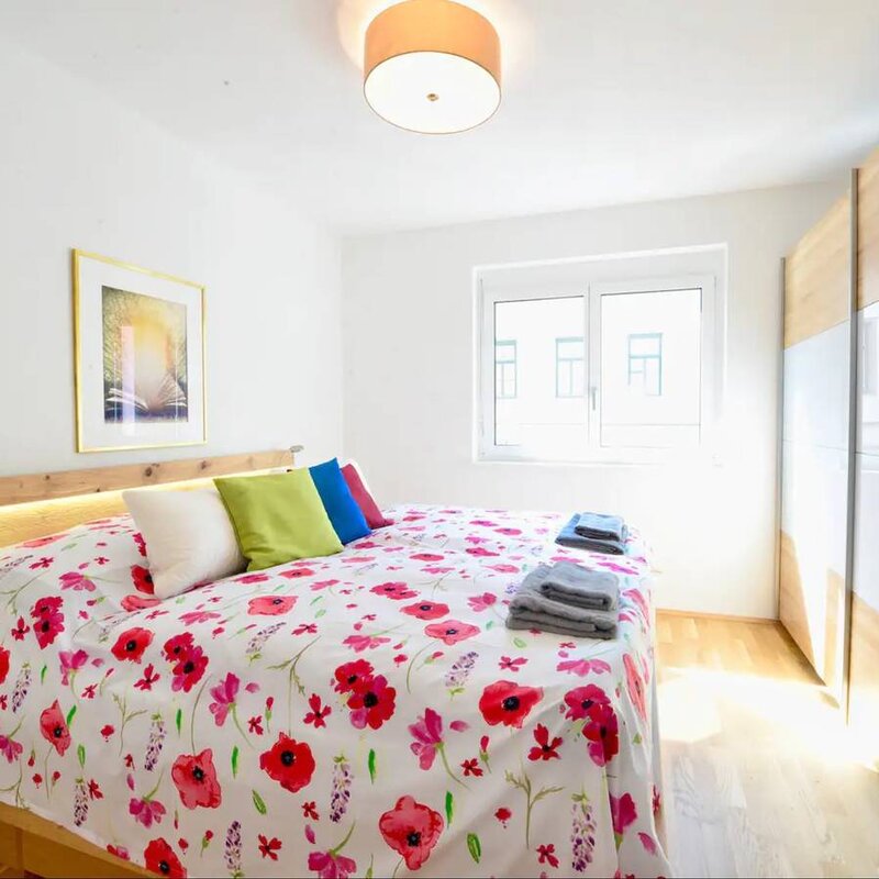 Helles Schlafzimmer mit Blumenbettwäsche & Einbauschrank – 2-Zimmer-Wohnung zur Kurzzeitmiete, Wohnen auf Zeit 1 bis 6 Monate, Wien
