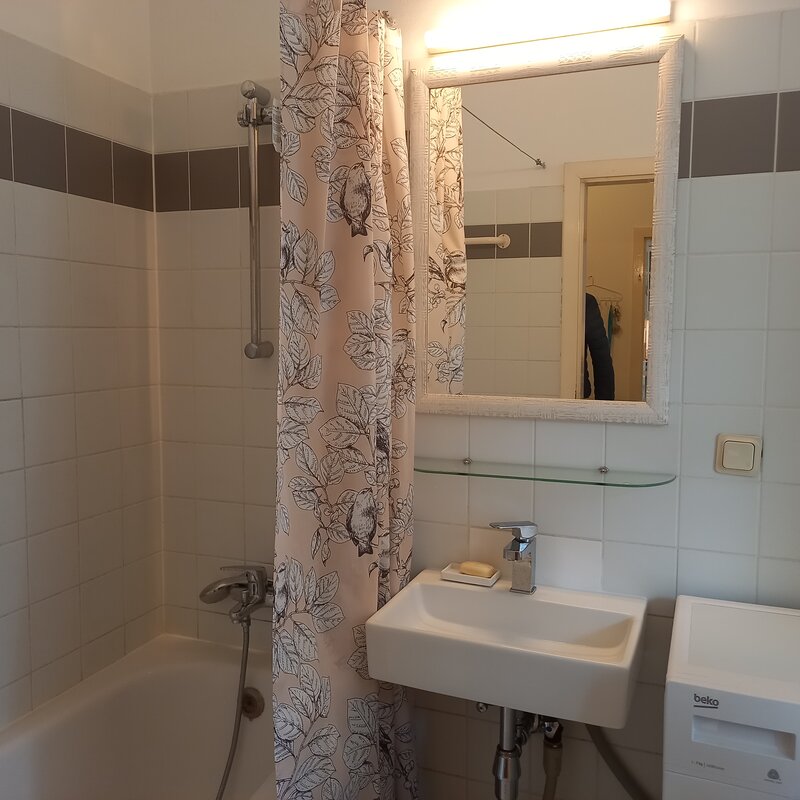 Badezimmer mit Wanne und Waschmaschine