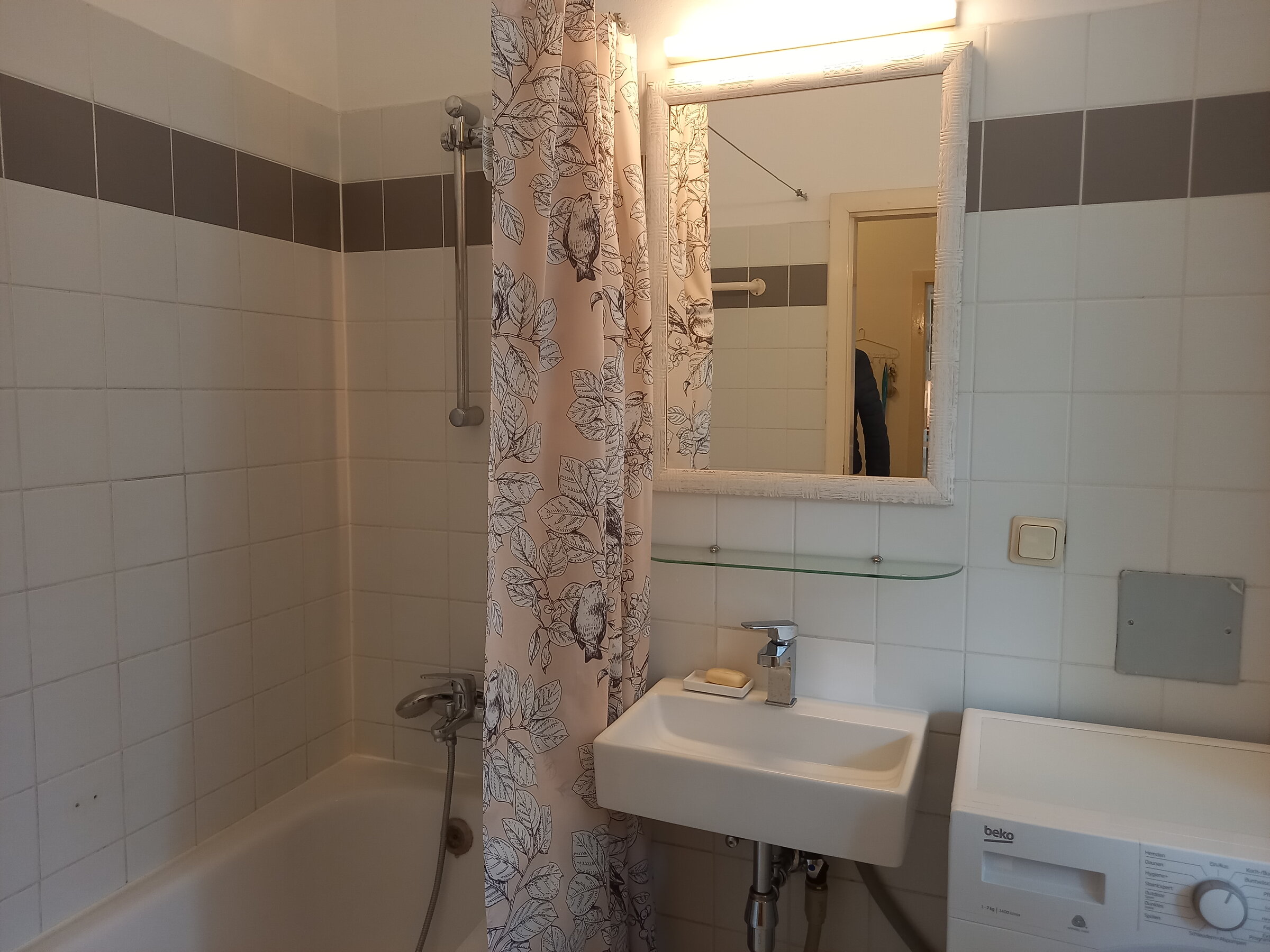 Badezimmer mit Wanne und Waschmaschine