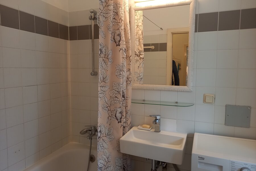 Badezimmer mit Wanne und Waschmaschine