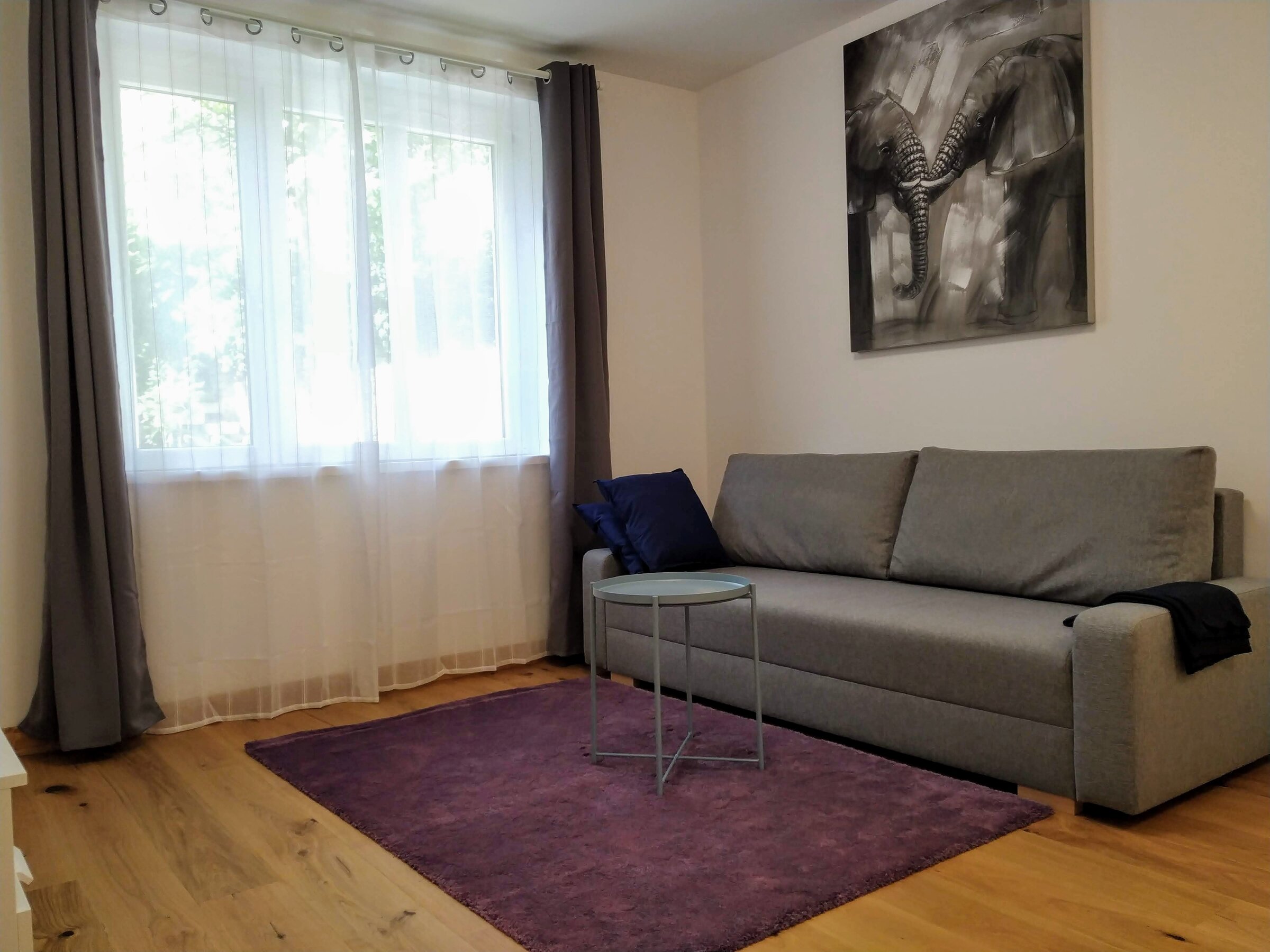 Helles Wohnzimmer mit Sofa & Parkettboden – 2-Zimmer-Wohnung, Kurzzeitmiete & Wohnen auf Zeit für 1 bis 6 Monate in Wien