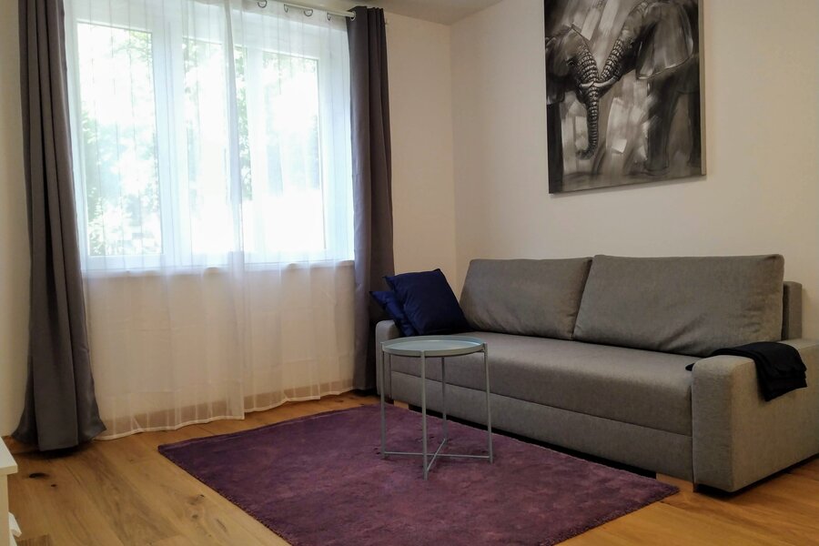 Helles Wohnzimmer mit Sofa & Parkettboden – 2-Zimmer-Wohnung, Kurzzeitmiete & Wohnen auf Zeit für 1 bis 6 Monate in Wien