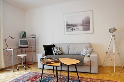 großzügiges Wohnzimmer mit TV und Arbeitsplatz