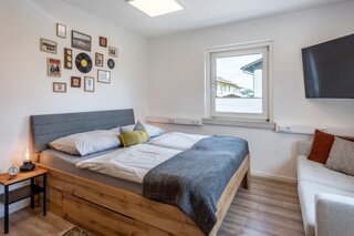 Schlafzimmer mit Schrank, Sofa und TV