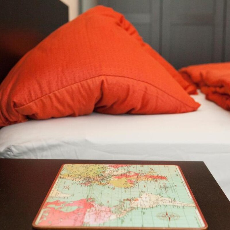 Cozy bedroom with orange pillows & decor – 1-room apartment for short-term rental, temporary housing for 1 to 6 months, Vienna