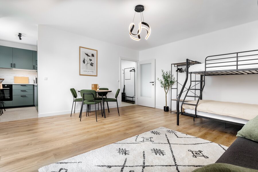 Living room with bunk bed and sofa bed as well as a dining area