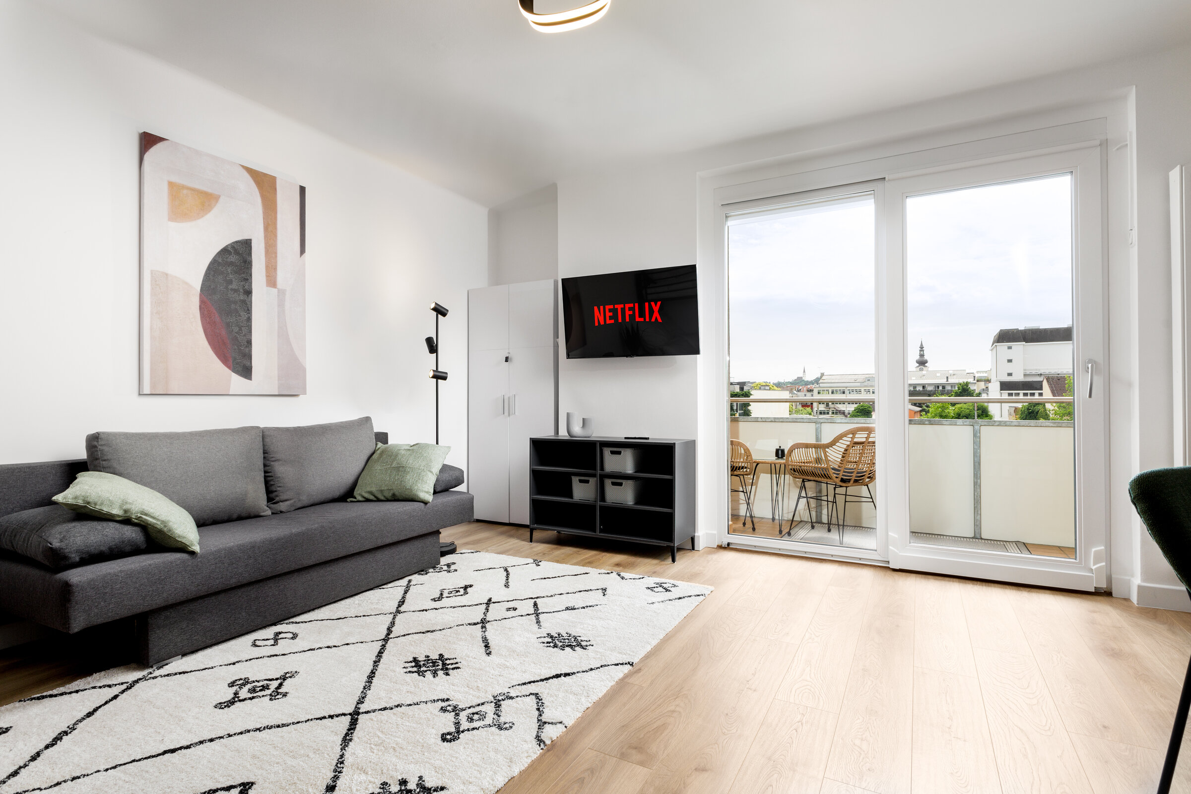 Modern and comfortable pull-out couch with NETFLIX TV and view of the balcony