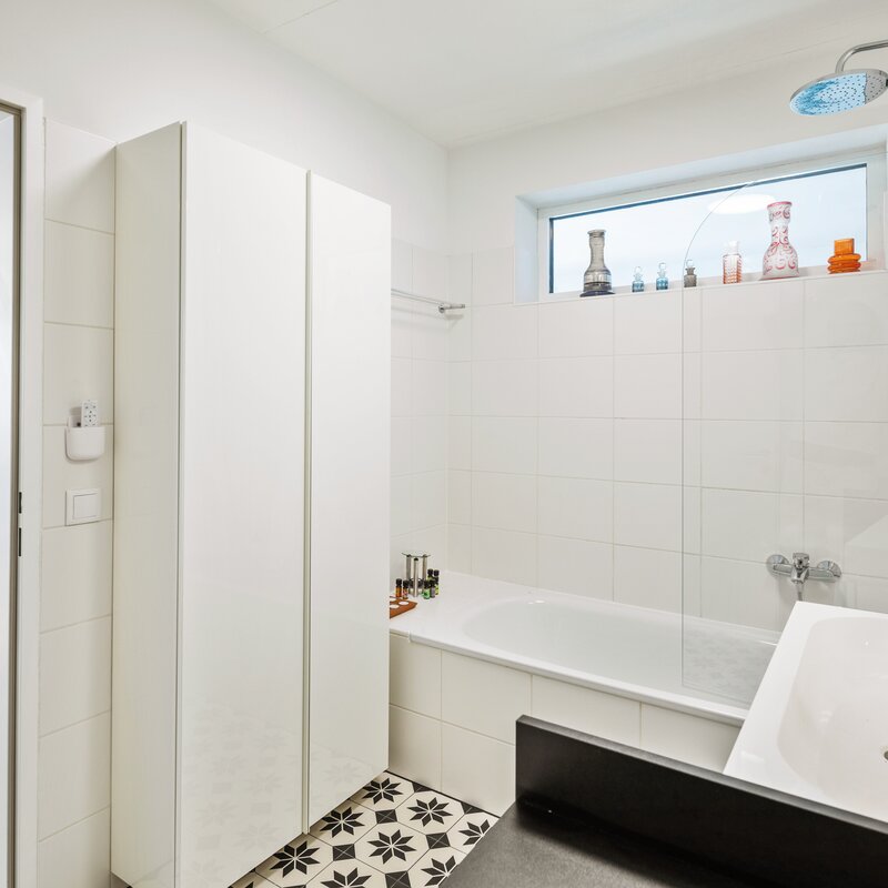 Bathroom with tub and cupboard