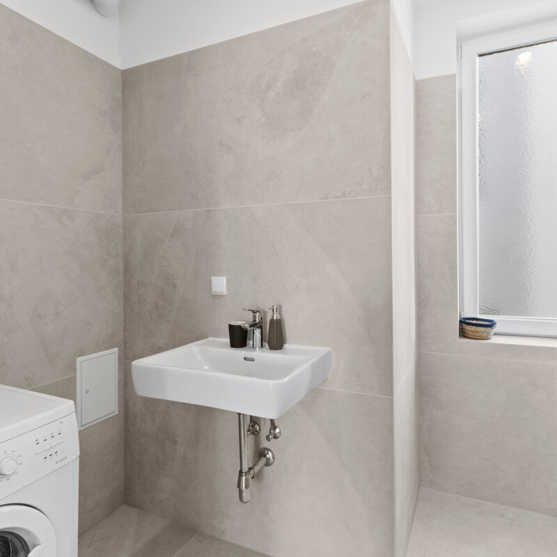 Badezimmer mit Dusche und Waschmaschine
