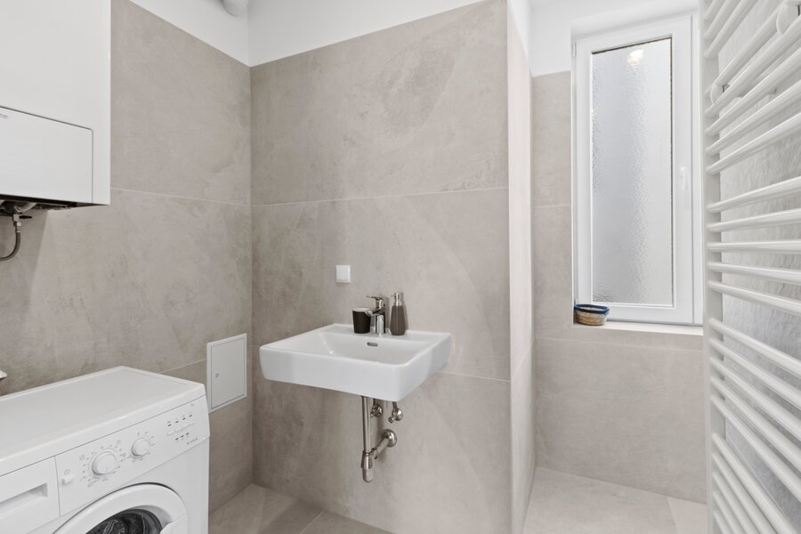 Badezimmer mit Dusche und Waschmaschine