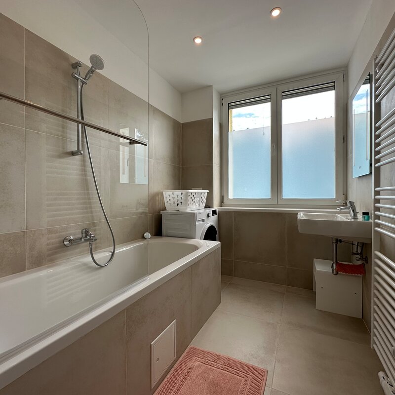 Badezimmer mit Badewanne und Waschmaschine