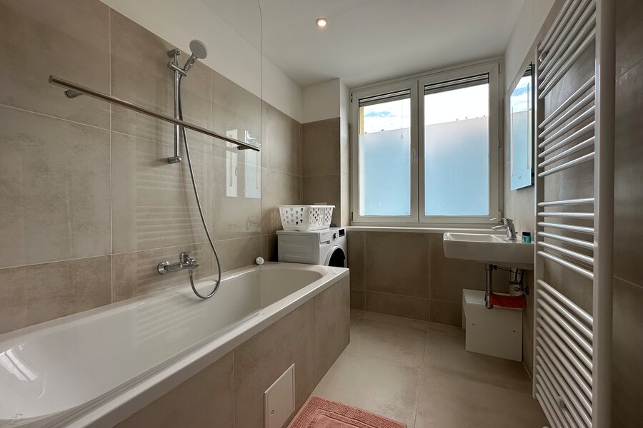 Badezimmer mit Badewanne und Waschmaschine