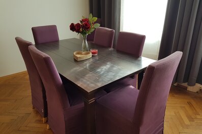 Stilvolles Esszimmer mit dunklem Holztisch & lila Stühlen – 3-Zimmer Wohnung, Kurzzeitmiete Wien, Wohnen auf Zeit 1–6 Monate.